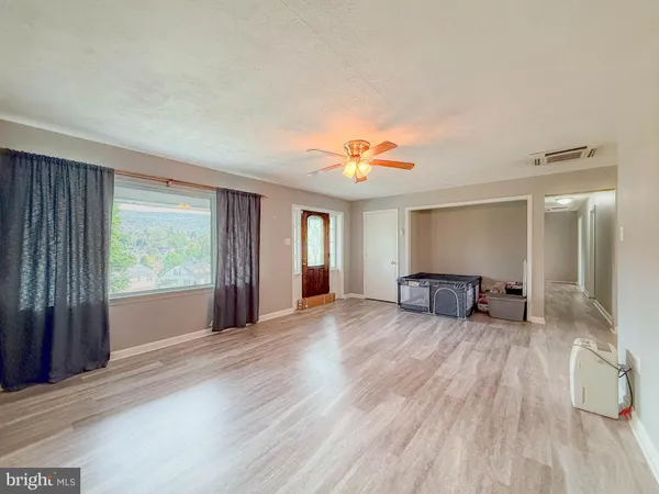 a view of a bedroom with baby crib and a window