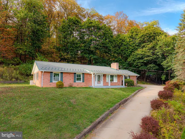 a front view of a house with a yard and trees