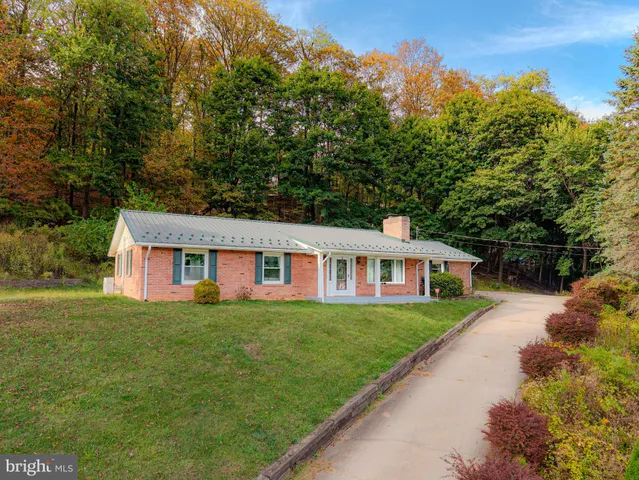 a front view of a house with a yard and trees