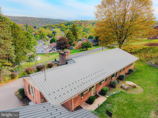 an aerial view of a house with a yard and lake view