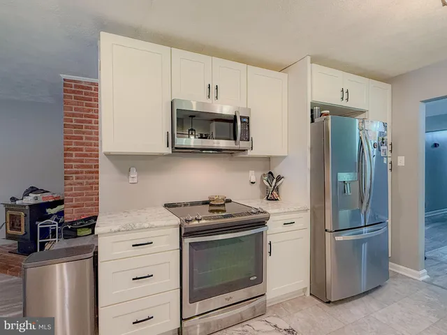 a kitchen with white cabinets and white appliances