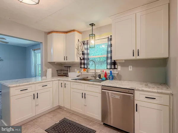 a kitchen with white cabinets and window