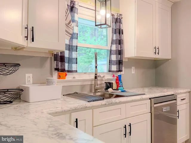 a view of a workspace with furniture and a window