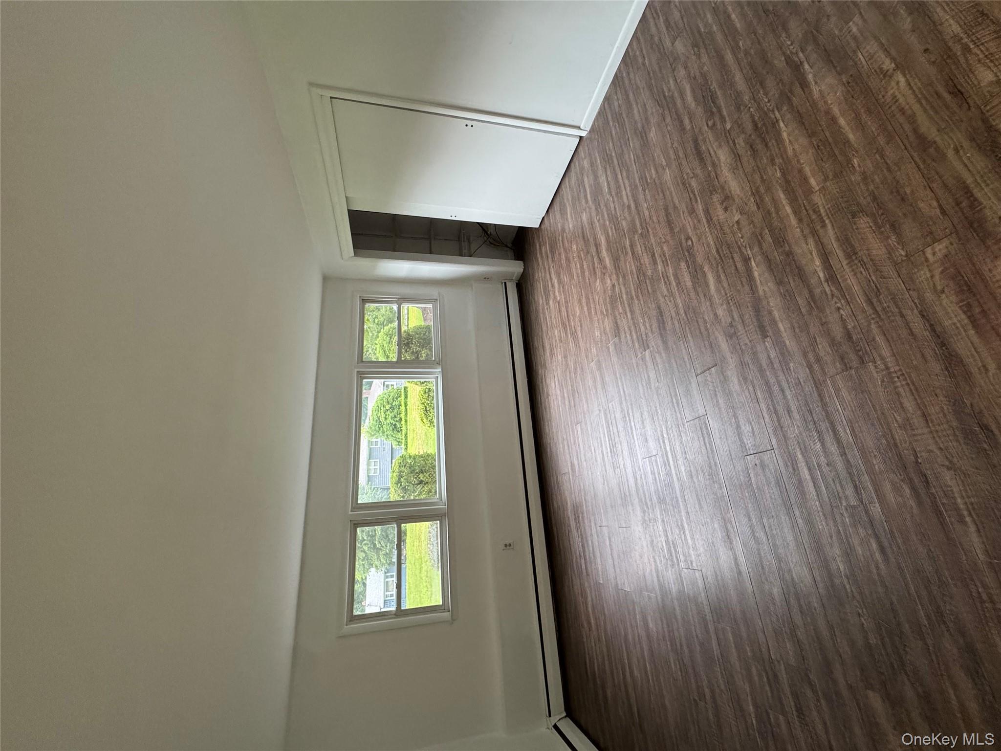 1145 Glen Road, Unit B Shrub Oak, NY 10588 - Photo 4 of 13 Unfurnished bedroom with dark wood-style floors, a baseboard heating unit, and a closet