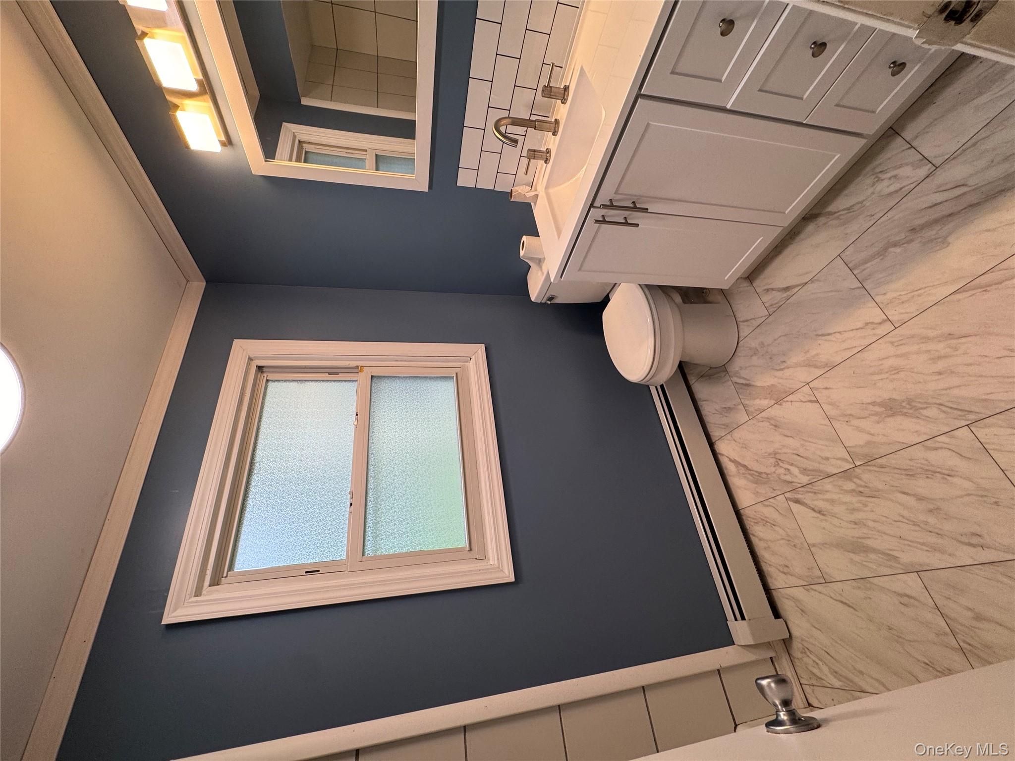1145 Glen Road, Unit B Shrub Oak, NY 10588 - Photo 6 of 13 Bathroom featuring vanity, a baseboard radiator, decorative backsplash, ornamental molding, and light marble finish floors