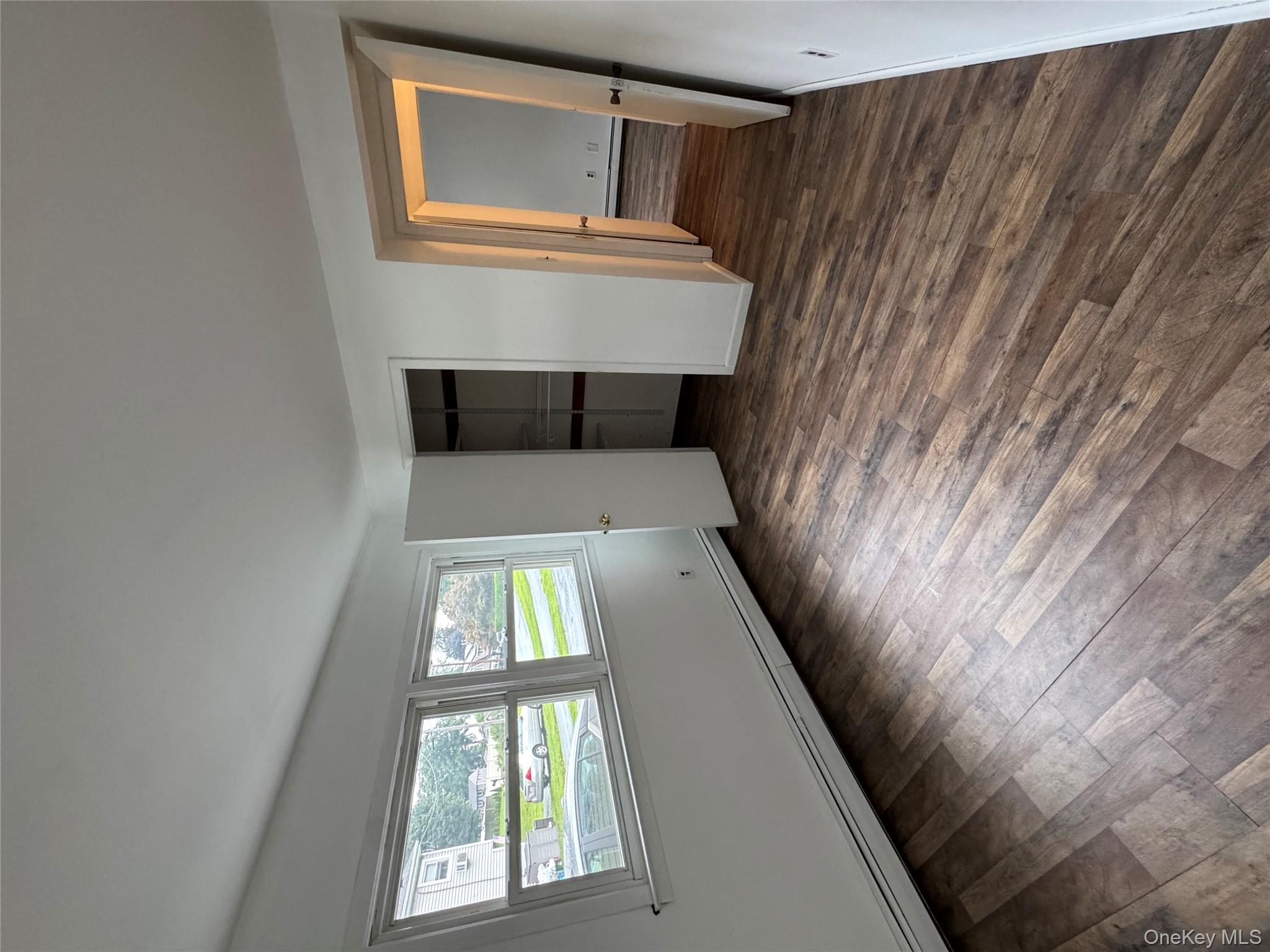 1145 Glen Road, Unit B Shrub Oak, NY 10588 - Photo 9 of 13 Unfurnished bedroom with a baseboard heating unit, dark wood-style flooring, and a closet