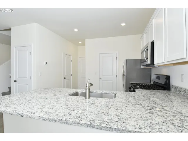 a kitchen with stainless steel appliances a refrigerator stove and microwave