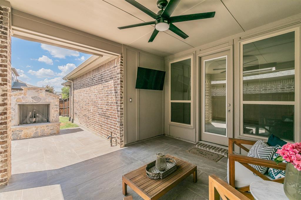 1205 Ivy Charm Way Arlington, TX 76005 - Photo 35 of 40 Covered patio featuring an outdoor stone fireplace, ceiling fan, and tiled flooring