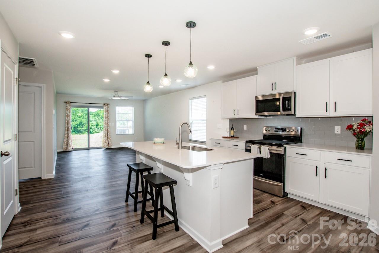 2742 Legacy Ridge Lane Catawba, NC 28609 - Photo 11 of 36 a kitchen with stainless steel appliances kitchen island granite countertop a stove a sink and a refrigerator