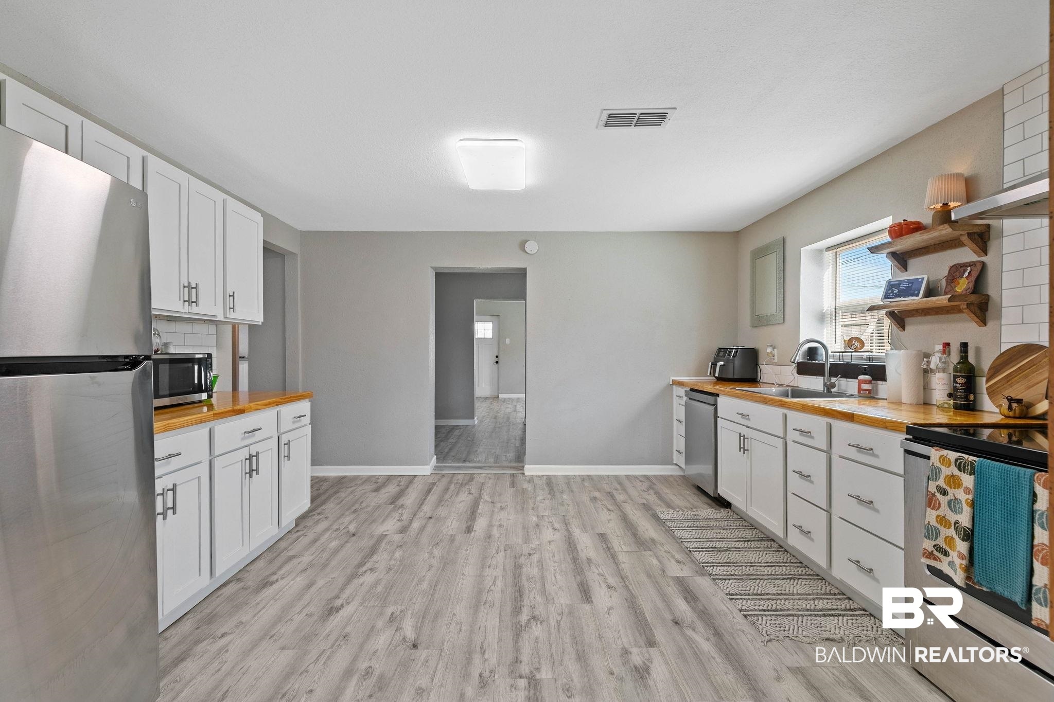 16796 Thompson Road Loxley, AL 36551 - Photo 27 of 93 Kitchen featuring butcher block counters, stainless steel appliances, backsplash, white cabinets, and open shelves