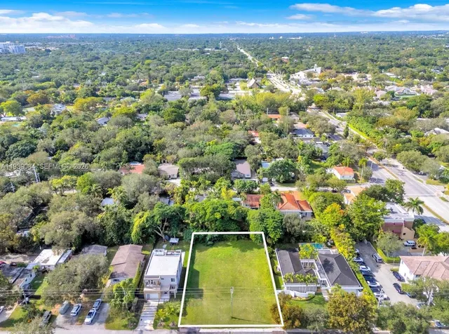 an aerial view of residential houses with outdoor space and trees