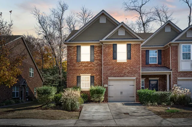 a front view of a house with plants and trees