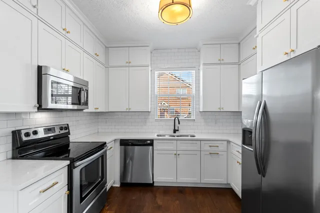 a kitchen with a sink appliances and cabinets