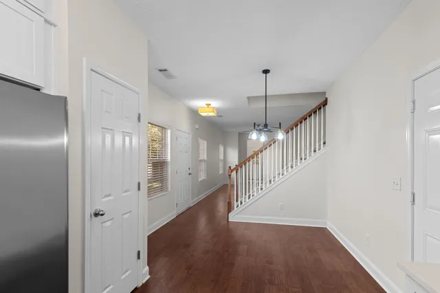 a view of a room with wooden floor and a ceiling fan