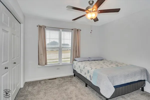 a bedroom with a bed and a ceiling fan