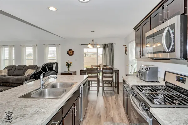 a kitchen with stainless steel appliances granite countertop a sink stove and cabinets