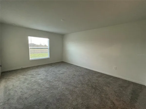 an empty room with closet and windows