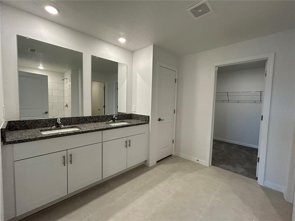 13095 Calcite Blue Avenue Wimauma, FL 33598 - Photo 18 of 28 a bathroom with double sink and a mirror