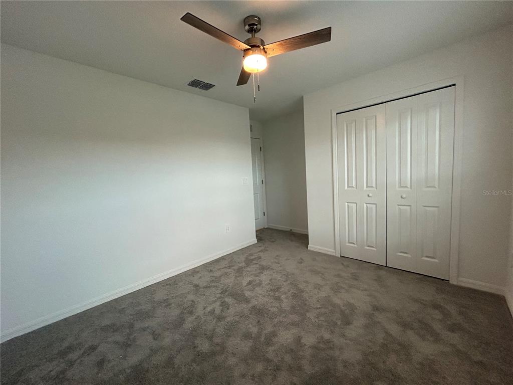 13095 Calcite Blue Avenue Wimauma, FL 33598 - Photo 20 of 28 an empty room with closet and a chandelier fan