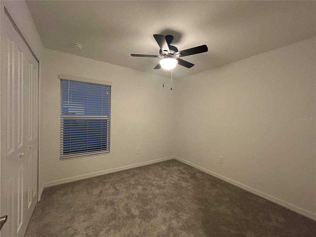 13095 Calcite Blue Avenue Wimauma, FL 33598 - Photo 23 of 28 an empty room with a window and a fan