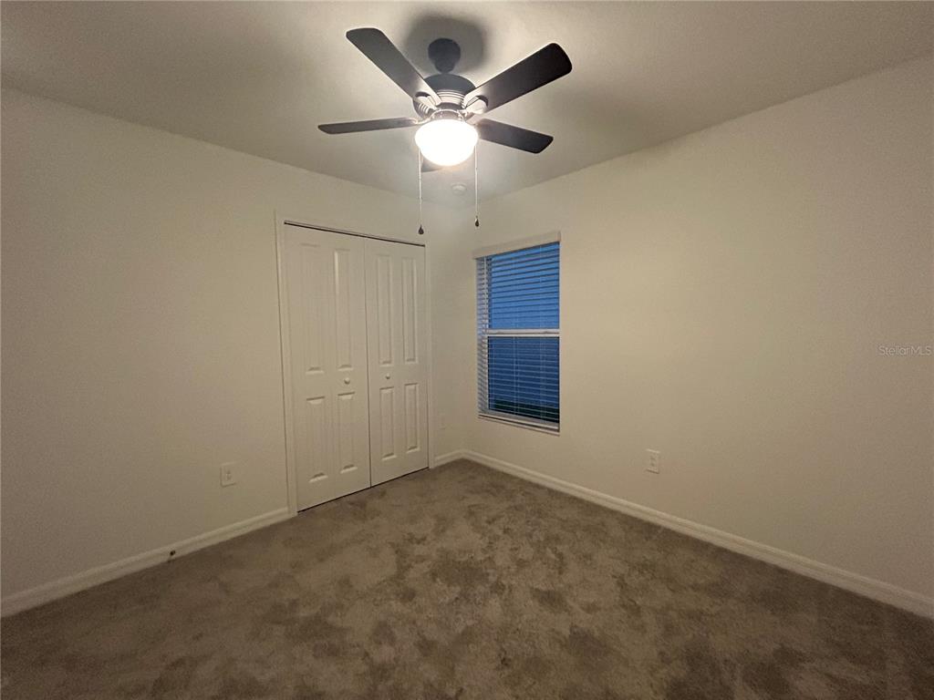 13095 Calcite Blue Avenue Wimauma, FL 33598 - Photo 24 of 28 an empty room with closet and ceiling fan