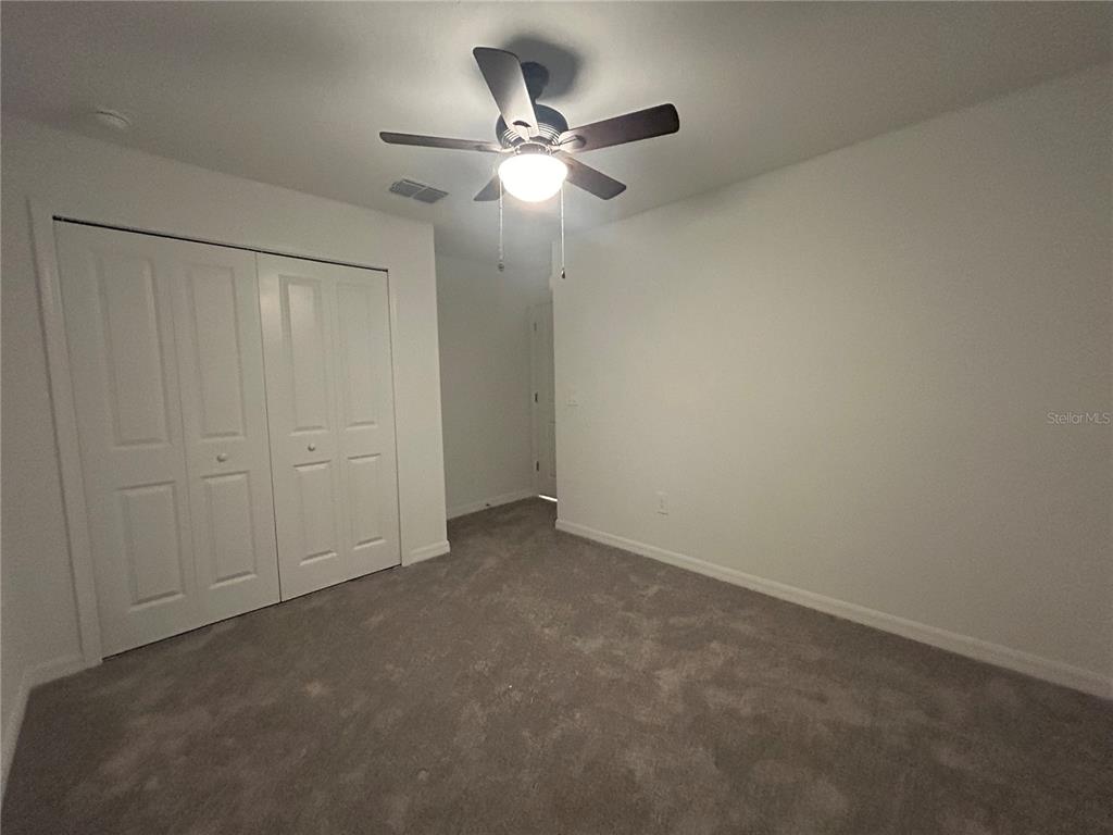 13095 Calcite Blue Avenue Wimauma, FL 33598 - Photo 28 of 28 an empty room with closet and ceiling fan