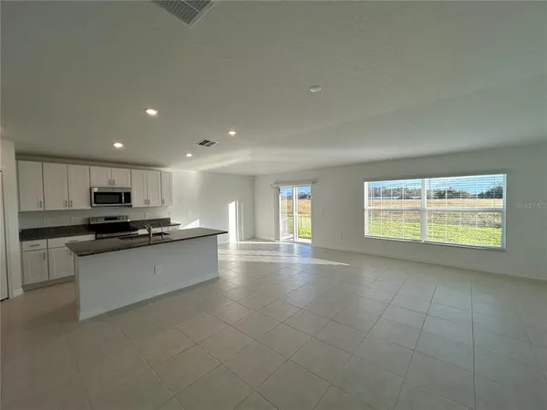 a large kitchen with a large counter top stainless steel appliances and a window