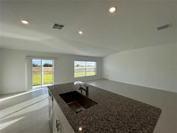 a kitchen with stainless steel appliances granite countertop a sink a stove and a window