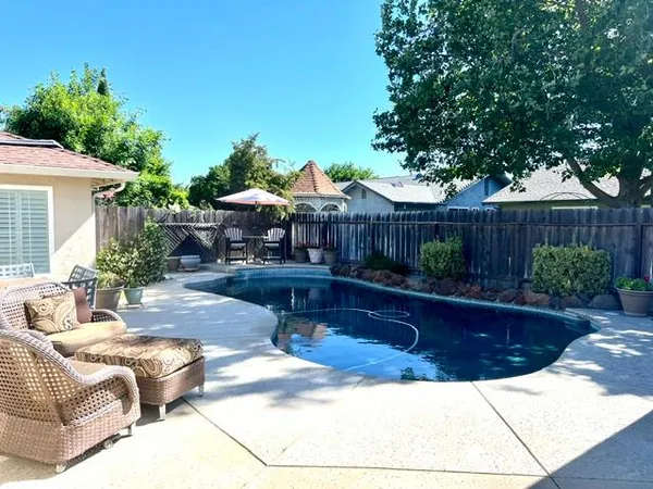 a view of swimming pool with table and chairs under an umbrella