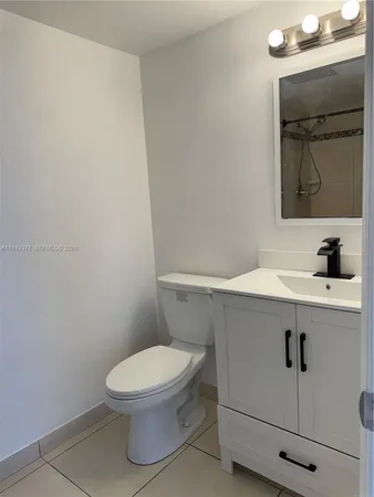 a bathroom with a toilet a sink and mirror