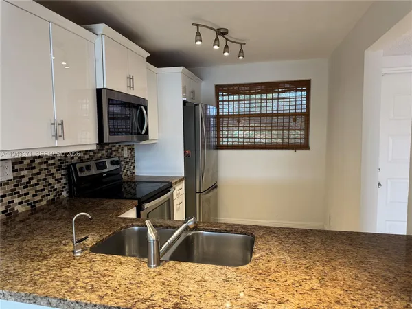 a kitchen with a sink a stove and microwave