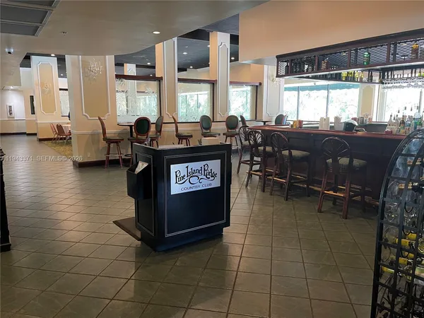 a living room with couches a dining table and chairs with a barbeque