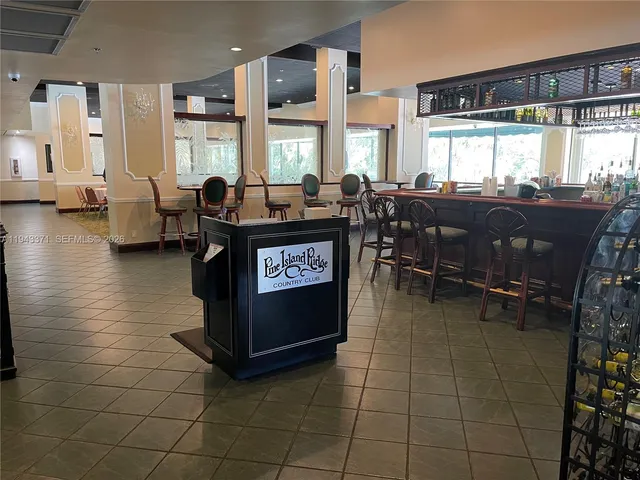 a living room with couches a dining table and chairs with a barbeque