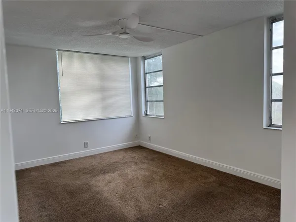 an empty room with windows and closet