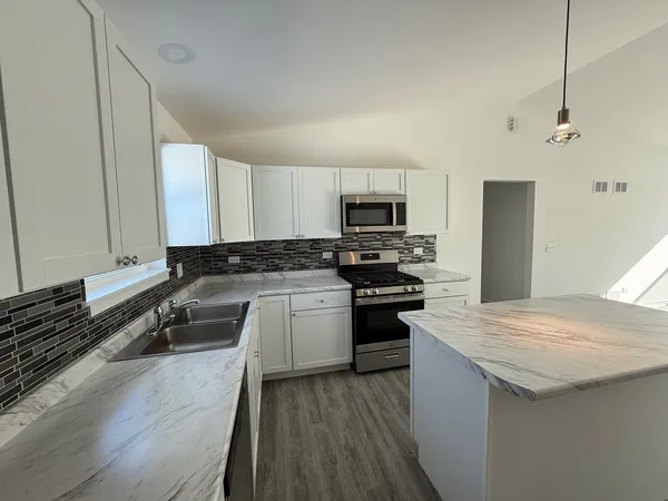 a kitchen with a sink a stove a microwave and refrigerator