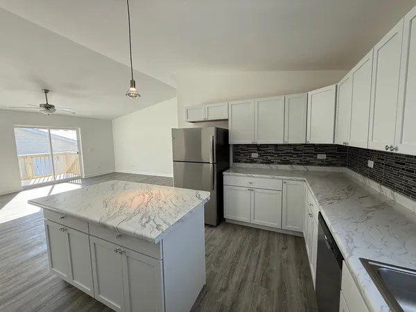 a kitchen with granite countertop a sink a counter space appliances and cabinets