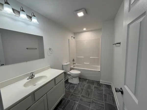 a bathroom with a double vanity sink toilet mirror and bathtub