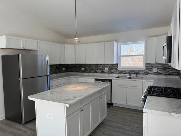 a kitchen with a refrigerator sink and cabinets
