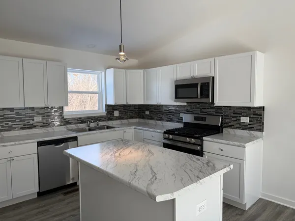 a kitchen with a sink a stove a microwave and cabinets