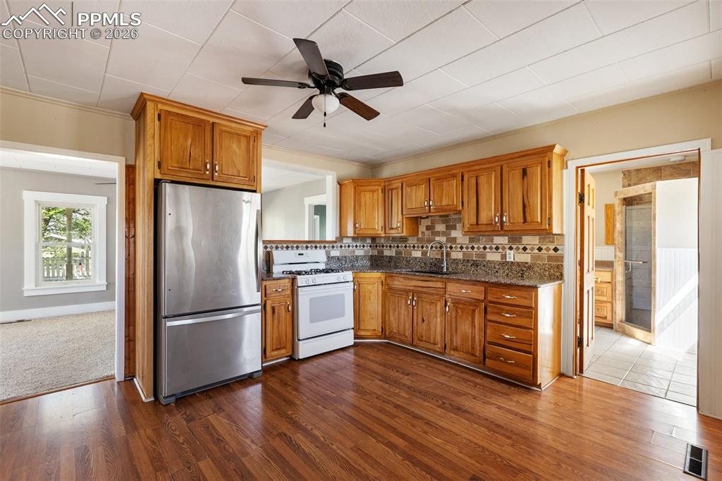 10355 Link Road Fountain, CO 80817 - Photo 15 of 45 a kitchen with granite countertop stainless steel appliances a refrigerator cabinets and wooden floor
