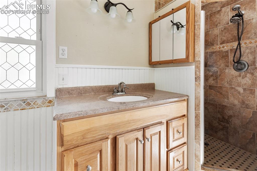 10355 Link Road Fountain, CO 80817 - Photo 18 of 45 a bathroom with a granite countertop sink a mirror and shower