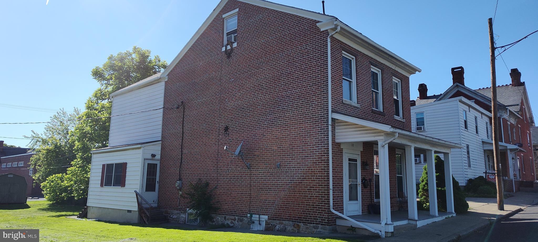 10 South 3rd Street Mifflintown, PA 17059 - Photo 2 of 9 a view of a brick house with many windows next to a yard