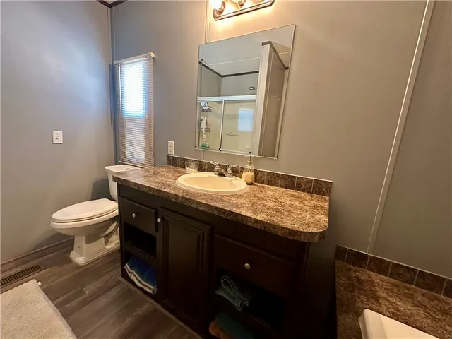 a spacious bathroom with a sink mirror vanity and toilet