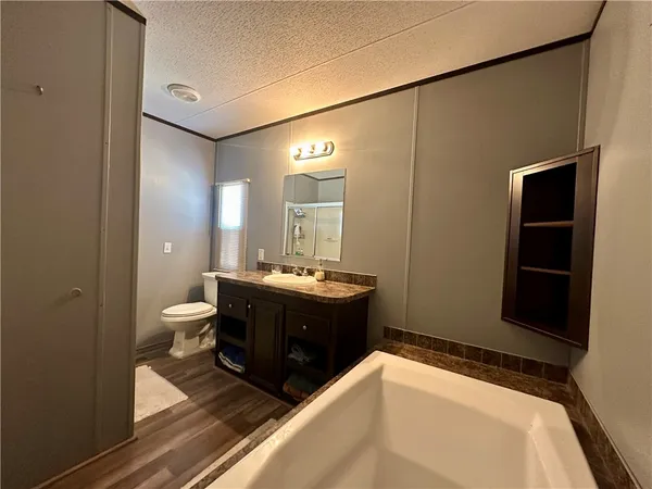 a bathroom with a granite countertop sink a mirror and shower