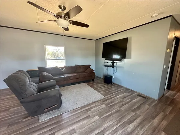 a kitchen with stainless steel appliances granite countertop a stove a refrigerator a sink a dining table and chairs with wooden floor