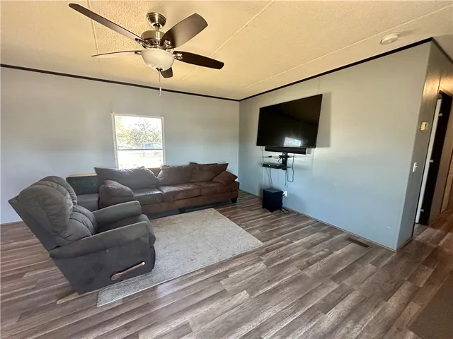 a kitchen with stainless steel appliances granite countertop a stove a refrigerator a sink a dining table and chairs with wooden floor