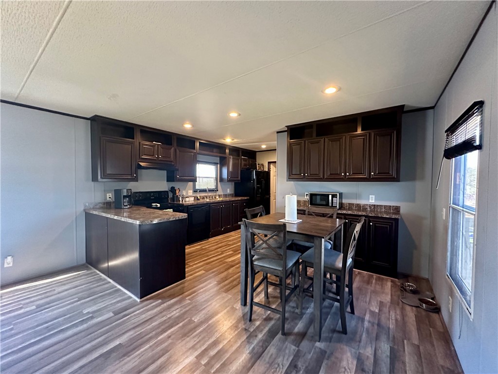 1708 Hill Street Sandia, TX 78383 - Photo 6 of 16 a kitchen with stainless steel appliances granite countertop a refrigerator a stove top oven a sink dishwasher a dining table and chairs with wooden floor