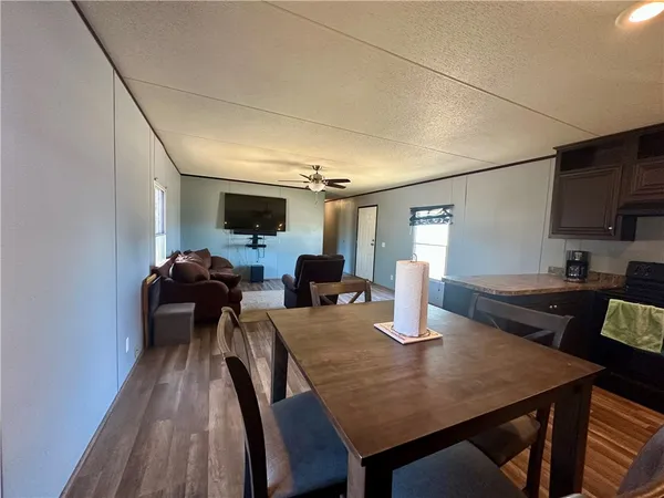 a kitchen with kitchen island granite countertop wooden cabinets and a refrigerator