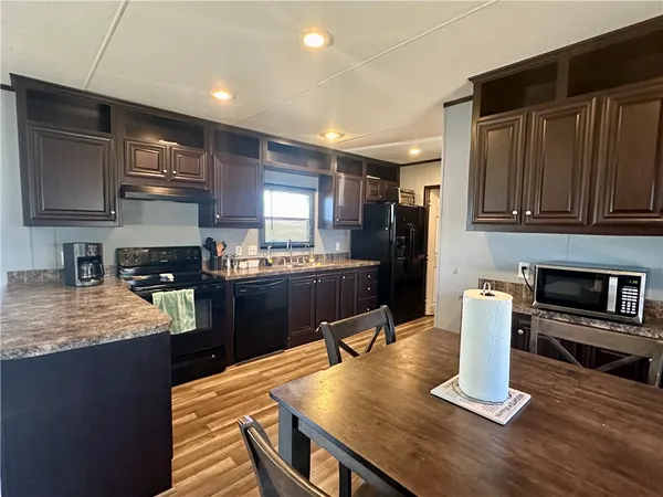 a kitchen with kitchen island granite countertop lots of counter top space and stainless steel appliances