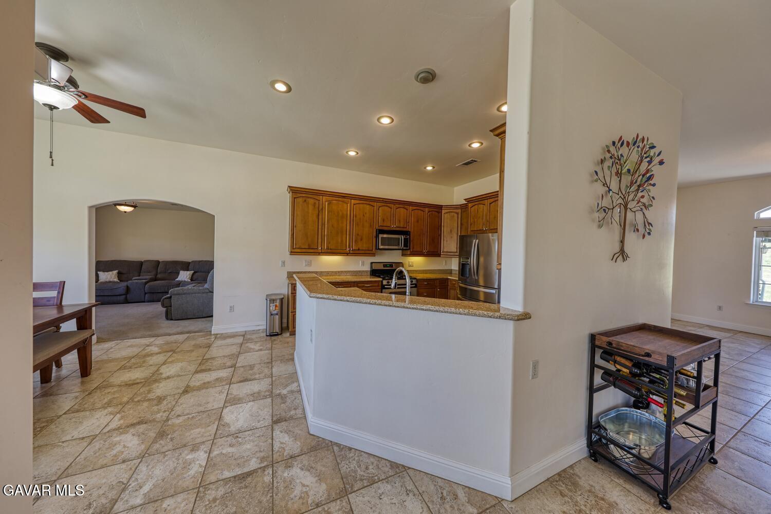 24500 Jacaranda Drive Tehachapi, CA 93561 - Photo 12 of 45 a kitchen with stainless steel appliances granite countertop a refrigerator and a stove top oven